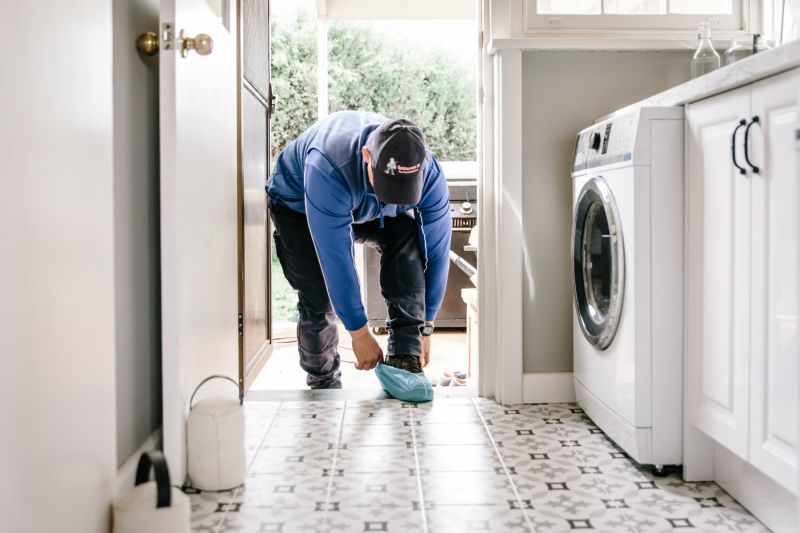 Putting on protective shoe coverings before pest control treatment inside house